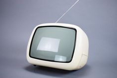 an old fashioned television with a white antenna on it's head and grey background