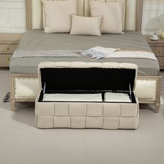 a bed with an ottoman underneath it in a bedroom