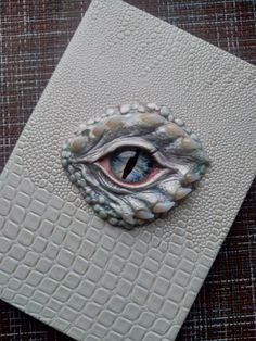 an eye is shown in the center of a card that has been made out of white leather