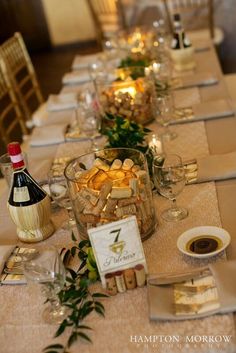 a long table is set with wine bottles and place settings for the guests to enjoy