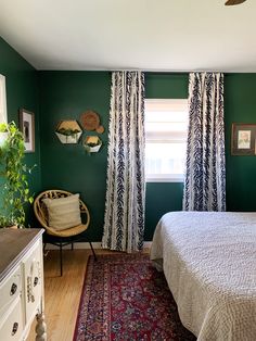 a bedroom with green walls and white curtains