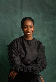 a woman in black sitting on a chair