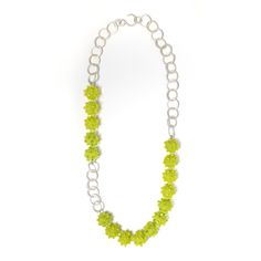 a necklace with green beads and silver chains on a white background, it looks like something from the movie star trek