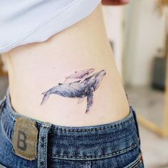 a woman's stomach with a tattoo of a whale on the back of her body