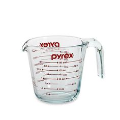 a measuring cup filled with liquid on top of a white surface