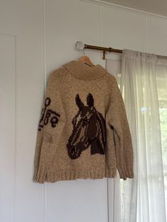 1950s vintage Cowichan knit cardigan zip up in hues of beige and browns. features horses face  on back and  horses body on front, with a branding graphic on sleeve.  very rare "tigers eye" glass orb pull hanging from talon zipper and shawl collar Unlabeled and handmade from a Mary Maxim pattern. Material feels like a wool blend. good vintage condition, as seen with repairs to sleeve and hole under arm and some discoloration.  see last pictures.  no interior tag or care label - handmade.  refer t Brown Vintage Cardigan, Mary Maxim Patterns, Cowboy Sweater, Western Cardigan, Horse Sweater, Mary Maxim, Glass Orb, Horse Face, Eye Glass