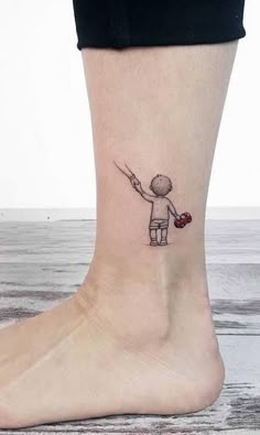 a small tattoo on the ankle of a person holding a knife and heart shaped object