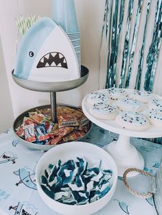 a table topped with plates and bowls filled with cookies