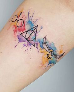 a harry potter tattoo on the arm with watercolor splatters and an owl