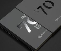 the front and back cover of a book with silver foil on it, sitting on a black surface