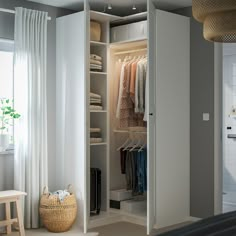 an open closet with clothes on hangers and other items in the room next to it