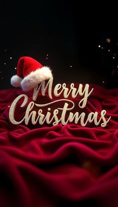 a merry christmas message with santa's hat on top of red blanketed fabric