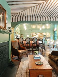 a living room filled with furniture and a fire place under a striped awning over the fireplace