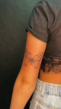 a woman with a butterfly tattoo on her stomach