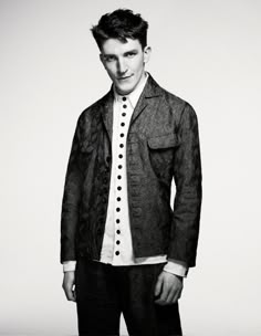 black and white photograph of a young man wearing a jacket with buttons on the front