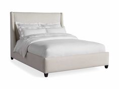 a bed with white linens and pillows on it's headboard, in front of a white background