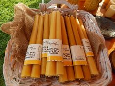 some candles are sitting in a basket on the grass and ready to be used as candle holders