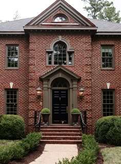 a large brick house with an entry way and steps leading up to the front door