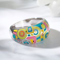 A bold ring features bright enamel colors in a geometric design, accented by sparkling white stones. A modern take on the classic design, this ring features bold enamel coloring, creating a bold, eye-catching design that looks fantastic wherever it is worn.  If you are looking for something simply gorgeous, this geometric painted ring is the perfect answer.Carat Weight: 0.14 ctStone Size: 1 mmStone Type: Jeulia® StoneNumber of Stones: 14 Stone Shape: RoundStone Color: Diamond WhiteWeight: 6.34 g Jewelry 2024, Enamel Rings, Bright Jewelry, Math Game, Bold Rings, White Stones, Painted Jewelry, Silver Jewellery Sets, Funky Jewelry