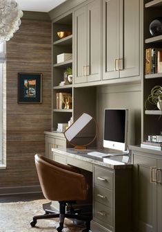 a desk with a computer on top of it in front of some bookshelves