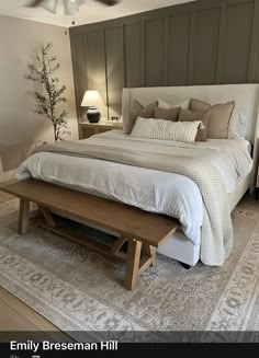 a bed room with a neatly made bed and a wooden bench on the floor next to it