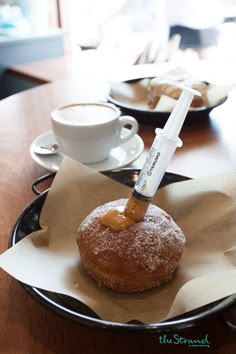 a donut is being filled with syrup by a syring on top of it