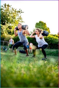 two people are doing exercises in the grass with boxing gloves on their hands and one person is holding a punching mitt