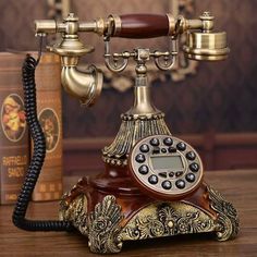 an old fashioned phone sitting on top of a wooden table