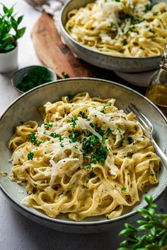 two bowls filled with pasta and parmesan cheese