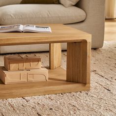 a coffee table made out of cardboard boxes on top of a carpeted floor with a couch in the background