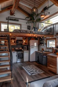 a kitchen and living room in a tiny house with stairs leading up to the loft