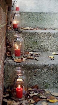 three jars with candles are sitting on the steps