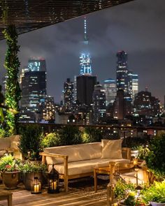 an outdoor seating area with city lights in the background