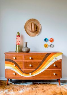 a hat is sitting on top of a dresser in a room with a cowhide rug