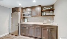 an empty kitchen with stainless steel appliances and wood cabinetry is pictured in this image