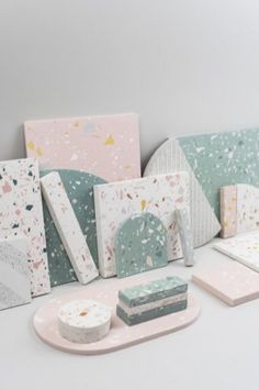 various pieces of art work displayed on a white surface with pastel colors and speckles