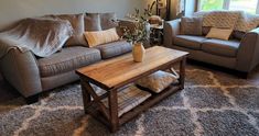 a living room with two couches and a coffee table in front of a window