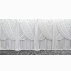 an empty room with white drapes on the wall