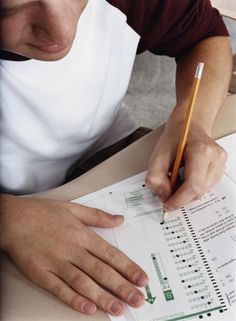 a man sitting at a table with a pencil in his hand