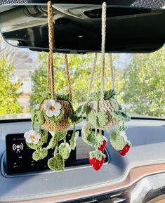 two crocheted ornaments hanging from the dashboard of a car