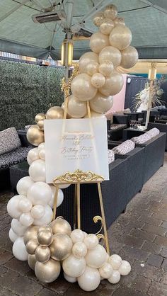 a table topped with balloons and a sign