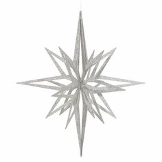 a silver star ornament hanging on a white wall