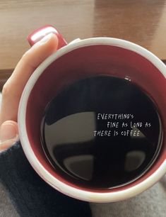 a person holding a coffee cup with the words everything is fine as long as there is coffee