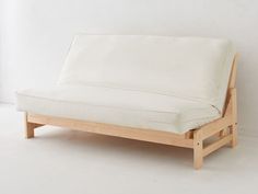 a white couch sitting on top of a wooden frame