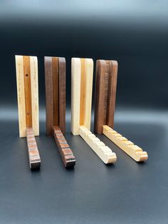 four pieces of wood sitting next to each other on top of a black countertop