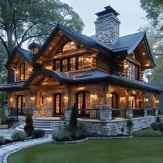 a very nice looking house with some lights on it's front porch and windows