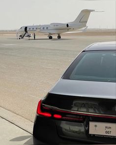 an airplane sitting on the tarmac next to a car