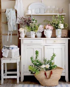 a white cabinet with flowers and plants on it