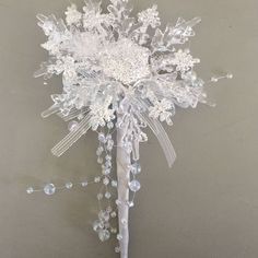 a white bridal bouquet with crystal beads and pearls on it's headpiece