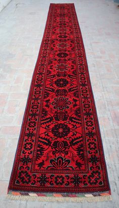 a red and black rug on the ground